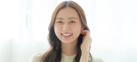 白い歯を見せて笑う女性の画像