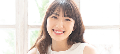 白い歯を見せて笑う女性の画像