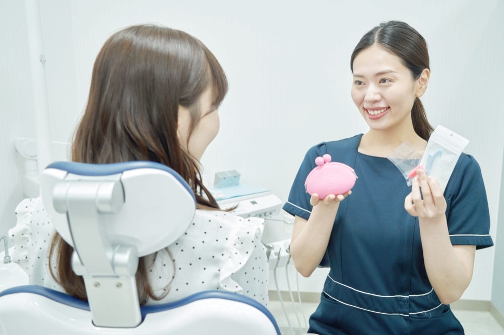 女性患者に説明する歯科衛生士